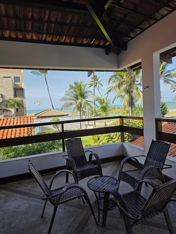 Varanda do segundo piso com vista para os coqueiros e o mar